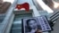 A placard with a photo of legal scholar Xu Zhiyong is raised by a demonstrator protesting against a Chinese court’s decision to sentence him in prison outside the Chinese liaison office in Hong Kong, Jan. 27, 2014.