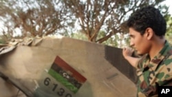 A Libyan rebel looks at the tail of a rebel MIG-23 jet in Benghazi on June 26, 2011 at the site where the jet crashed after it was shot down on March 19, 2011.