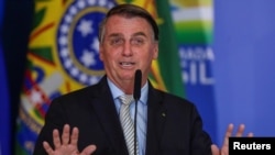 FILE - Brazil's President Jair Bolsonaro gestures at the Planalto Palace in Brasilia, Brazil, Feb. 24, 2021.