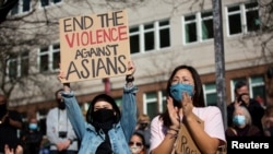  Dawn Cheung and Victoria Do clap and cheer while listening to speakers during a protest against anti-Asian hate crimes at Hing Hay Park in the Chinatown-International District of Seattle, Washington, March 13, 2021. 