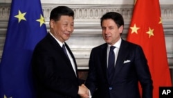 Chinese President Xi Jinping, left, and Italian Prime Minister Giuseppe Conte shake their hands following the signing of a memorandum in support of Beijing's "Belt and Road" initiative, at Rome's Villa Madama, March 23, 2019.