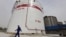 FILE - An employee walks past oil tanks at a Sinopec refinery in Wuhan, Hubei province April 25, 2012. China’s top state-owned refiners have decided not to order any oil for loading at Iranian ports this month, according to Reuters.