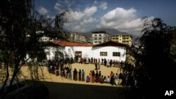 FILE- In this March 24, 2008 file photo, Bhutanese people queue up to cast their votes outside a polling station, in Thimphu, Bhutan.Bhutan’s COVID-19 vaccination drive was fast from the start. As other countries rolled out their vaccination campaigns…