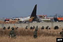 South Korean soldiers search for missing passengers near the wreckage of a Jeju Air Boeing 737-800 series aircraft after the plane crashed and burst into flames at Muan International Airport in South Jeolla Province, South Korea, Dec. 29, 2024.