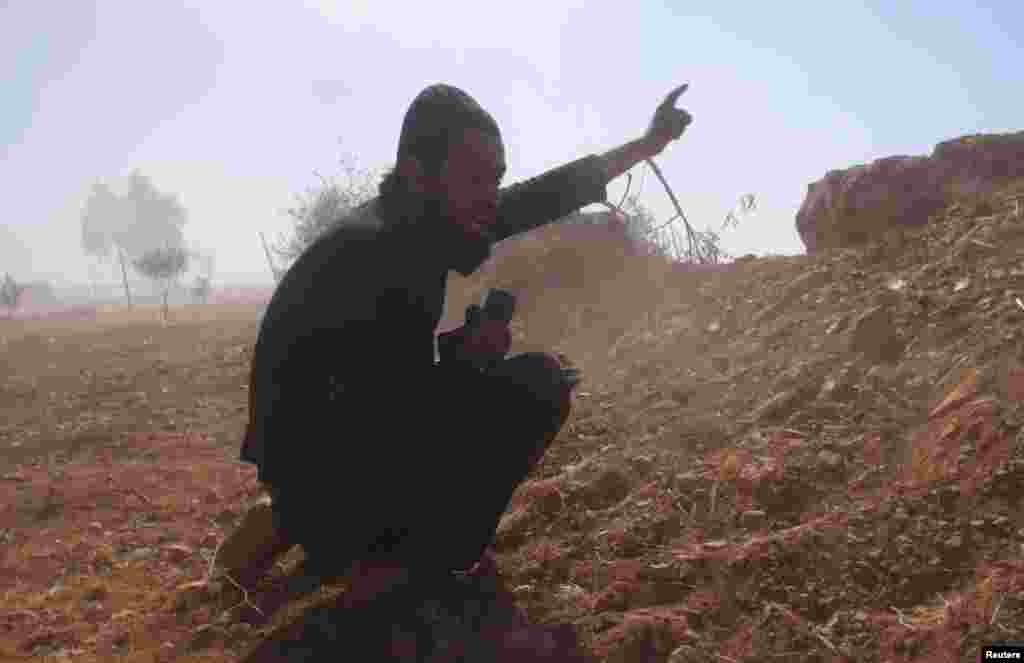 A Free Syrian Army fighter reacts during what the FSA said were clashes with forces loyal to Syria's President Bashar al-Assad in the eastern Hama countryside, Oct. 14, 2013. 