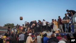 แฟ้มภาพ - ชาวปาเลสไตน์แห่ปีนขึ้นรถบรรทุกความช่วยเหลือด้านมนุษยธรรมที่ถูกขนส่งผ่านท่าเรือที่สหรัฐฯ สร้างให้ มายังใจกลางฉนวนกาซ่า เมื่อ 18 พ.ค. 2567