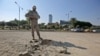 A member of the Iraqi security forces inspects the damage outside the Zawraa park in the capital Baghdad, Nov. 18, 2020, after volley of rockets slammed into the Iraqi capital breaking a month-long truce on attacks against the U.S. embassy.