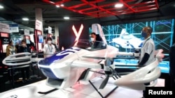 Un participant regarde une voiture volante SkyDrive à émission zéro lors du CES 2022 à Las Vegas, Nevada, États-Unis, le 6 janvier 2022. 