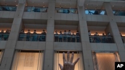 A protester gestures with five fingers, signifying the "Five demands - not one less" in a shopping mall during a protest against China's national security legislation for the city, in Hong Kong, June 1, 2020. 
