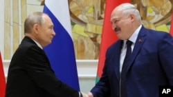 FILE - Russian President Vladimir Putin, left, and Belarusian President Alexander Lukashenko shake hands during a signing ceremony in Minsk, Belarus, Dec. 6, 2024. 
