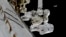In this frame from NASA TV, astronauts Mark Vande Hei and Randy Bresnik, bottom, work on the International Space Station, Oct. 5, 2017.