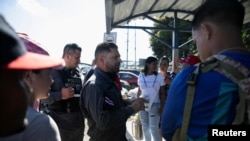FILE - Costa Rican migration police officers speak with Venezuelan migrants at the Costa Rica - Panama border in Paso Canoas, Costa Rica, Feb. 12, 2025. 
