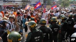 Cambodian riot police officers block protesters led by Cambodia's most prominent human rights defender Mam Sonando demanding the government to allow him to open a new television channel in Phnom Penh, Cambodia, Jan. 27, 2014. 