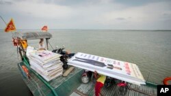 আসামের জোরহাটে একজন প্রার্থীর বিলবোর্ড নিয়ে নৌকা ব্রহ্মপুত্র নদী পাড়ি দিচ্ছে। ফটোঃ ১৭ এপ্রিল, ২০২৪। 