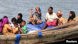 FILE - Muslim Rohingya people on a boat cross the river Naf, from Myanmar into Teknaf, Bangladesh, June 11, 2012. 