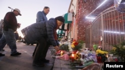 民众在加州蒙特利帕克市发生枪击案的舞厅外摆放鲜花致意（2023年1月23日）