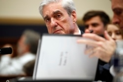 Former special counsel Robert Mueller checks pages in the report as he testifies before the House Judiciary Committee on his report on Russian election interference, Capitol Hill, July 24, 2019 in Washington.