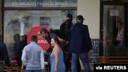 FILE - Unidentified men wearing face coverings detain a man near a cafe during an opposition rally challenging presidential election results in Minsk, Belarus, Sept. 6, 2020. (Tut.By via Reuters) 