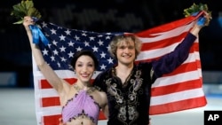 Meryl Davis and Charlie White of the U.S. pose for photographers after placing first in the Olympic ice dance free dance figure skating finals in Sochi, Feb. 17, 2014.