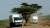 Trucks separate to avoid a tree on a major road from Nairobi, the capital of Kenya, to the sea port of Mombasa, Feb. 12, 2007.