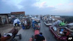 Truk-truk warga sipil mengungsi dari serangan militer Suriah di provinsi Idlib di jalan utama dekat Hazano, Suriah, 24 Desember 2019. (Foto: dok).