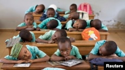 FILE - Boys rest their heads on their desks during a language class in Cameroon's capital, Yaounde. Strikes by teachers and lawyers to push for more use of English have turned violent, and schools have closed.