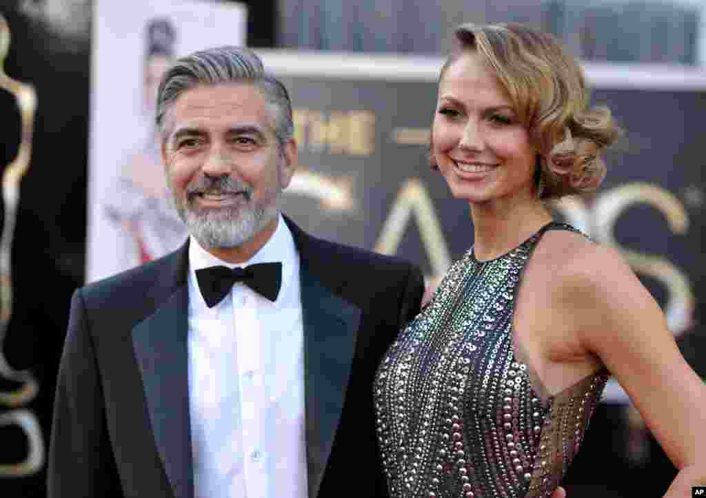 Actors George Clooney, left, and Stacy Keibler arrive at the Oscars at the Dolby Theatre on Feb. 24, 2013, in Los Angeles.