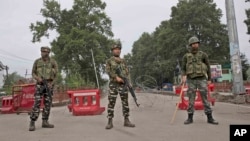 Tentara paramiliter India berjaga dengan pos pemeriksaan sementara menjelang pawai Hari Kemerdekaan saat berlangsung pembatasan di Srinagar, wilayah Kashmir yang dikuasai India, 15 Agustus 2019. 