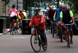 People cycle through Westminster area of London, Sunday, May 10, 2020 during the nation-wide coronavirus lockdown.