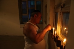 FILE - In this Aug. 29, 2009, photo, Zebulon Simentov, the last known Jew living in Afghanistan, lights the candles at the start of Shabbat in the synagogue he cares for in Kabul.