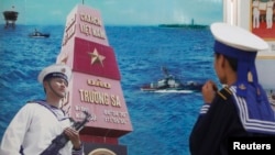 Một người lính hải quân Việt Nam đang ngắm một bức tranh cổ động về quần đảo Trường Sa trong một cuộc triển lãm. 