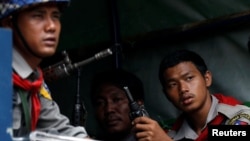 FILE - Myanmar police officers sit in a truck while patrolling a road in Maungdaw, Myanmar, August 31, 2017.