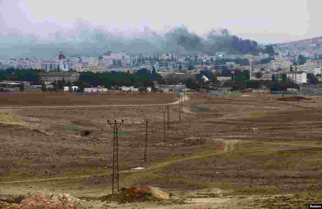 Smoke rises from the Syrian town of Kobani, seen from near the Mursitpinar border crossing on the Turkish-Syrian border in the southeastern town of Suruc in Sanliurfa province, Oct. 17, 2014.