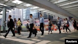 រូប​ឯកសារ៖ បុគ្គលិក​រដ្ឋាភិបាល នៅ​ខាង​ក្រៅ​អគារ​ដ្ឋាភិបាល​មួយ​កន្លែង​នៅ​ទី​ក្រុង​ហុងកុង ប្រទេស​ចិន កាល​ពី​ឆ្នាំ​២០១៤។