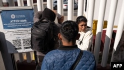 Asylum seekers wait for news on their CBP One appointments with US authorities before crossing through El Chaparral port in Tijuana, Baja California state, Mexico, on January 20, 2025.
