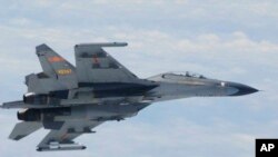 In this undated photo released by Japan Ministry of Defense, a Chinese SU-27 fighter plane is shown. China and Japan are blaming each other for a close encounter between military jets over the East China Sea.