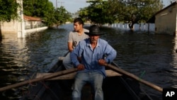 Victor Ferreira, who was displaced by flooding, rows his boat through the streets of his Jukyty neighborhood in Asuncion, Paraguay, Dec. 23, 2015. The Paraguay River is at its highest level since 1984.