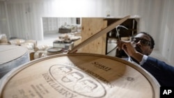 Victor Yarbrough, CEO of Brough Brothers Distillery, removes the cover from an empty barrel of bourbon in the under-construction facility in Louisville, Kentucky, March 8, 2025.