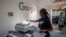 FILE - A woman makes copies at the Google Artificial Intelligence (AI) office in Accra, on Apr. 10, 2019. 