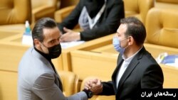 عزیزی خادم(راست) در کنار علی کریمی در جریان انتخابات