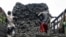 FILE - Somali porters offload charcoal from a truck at a charcoal market in Mogadishu, Oct. 30, 2012.