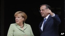 Kanselir Jerman Angela Merkel dan PM Yunani Antonis Samaras berbicara di Athena (9/10/2012). Isu pengampunan utang Yunani menjadi isu penting kampanye politik di Jerman.