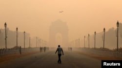 A man walks in front of the India Gate shrouded in smog in New Delhi, India, Oct. 29, 2018.