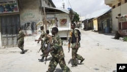 Somali government soldiers patrol in Mogadishu's Bakara market, August 8, 2011