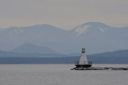 A view as the sun tries to breakthrough the clouds looking towards New York State from Burlington Bay Lake Champlain in Burlington, Vermont on March 11, 2020.