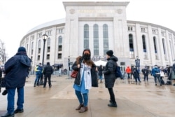 FILE - People line up at a COVID-19 vaccination site at Yankee Stadium, Feb. 5, 2021, in the Bronx borough of New York.