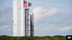 This NASA image shows an unmanned Atlas V rocket, which will hoist an Orbital ATK cargo capsule into space, rolling out of the vertical integration facility to the launch pad at Cape Canaveral, Fla., Dec. 2, 2015.