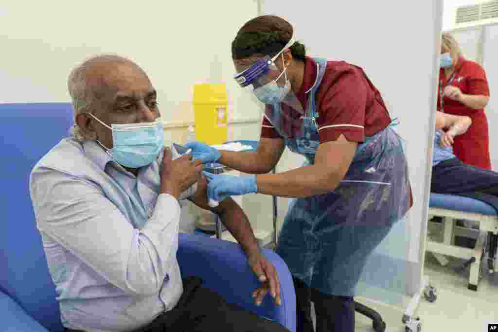 Care home worker Pillay Jagambrun, 61, receives the Pfizer/BioNTech COVID-19 vaccine in The Vaccination Hub at Croydon University Hospital, south London, on the first day of the largest immunization program in the UK's history, Dec. 8, 2020.