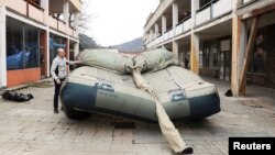 A worker prepares an inflatable decoy of a military vehicle, which is used to confuse enemy attacks, during a media presentation in Decin, Czech Republic, March 6, 2023.