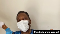 Pelé levanta el pulgar en señal de aprobación mientras recibe la vacuna contra la COVID-19, en esta foto tomada por su esposa Marcia Aoki, y publicada por el astro en su página de Instagram.